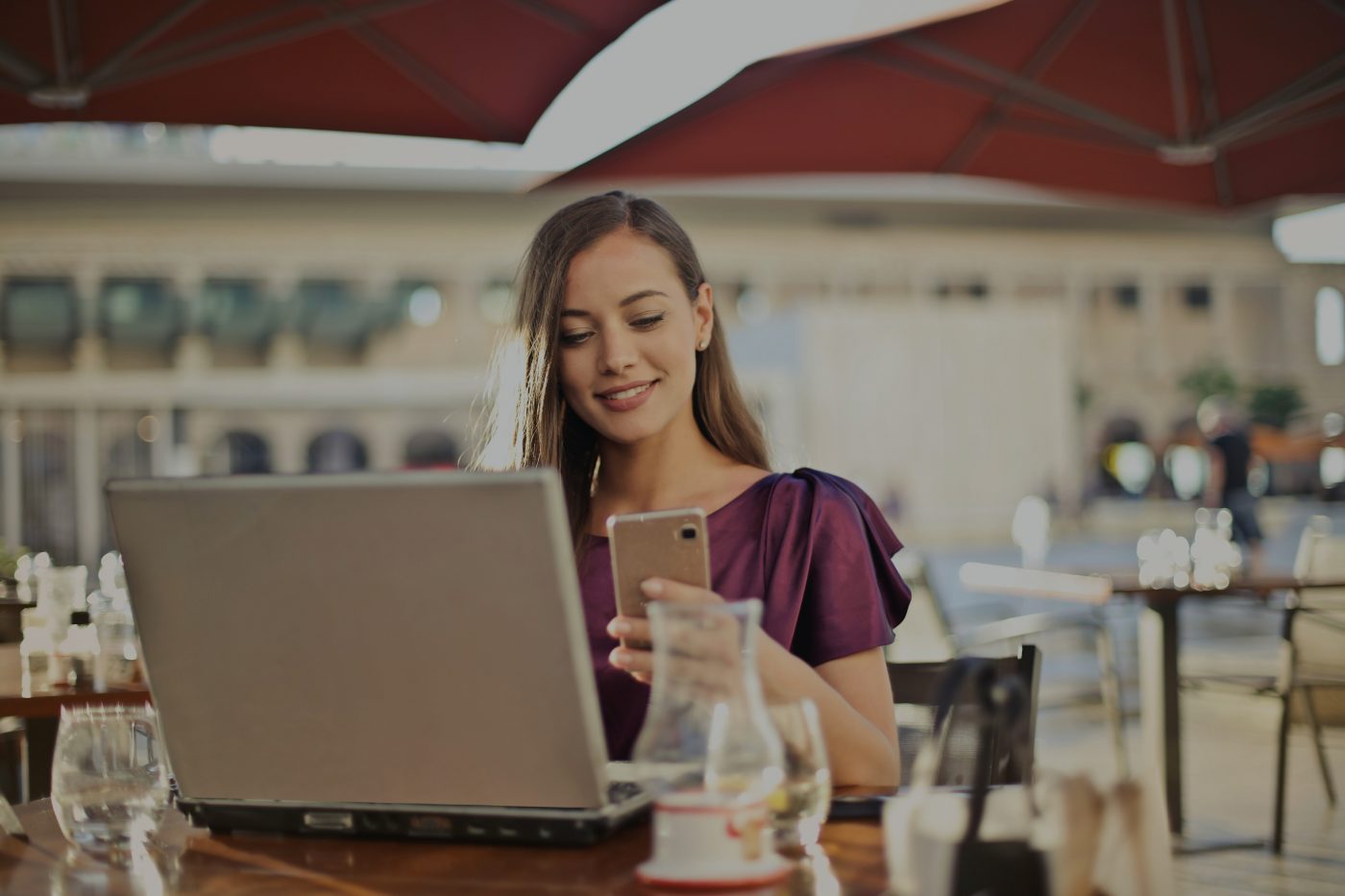 Woman looking at phone while sat in a cafe